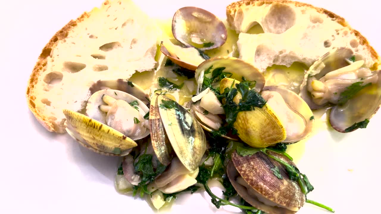 close view of Clams &agrave; Bolh&atilde;o Pato with bread and plenty of garlic, a classic and popular dish in Portugal