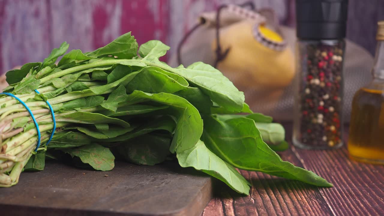 Mazzo di spinaci freschi su un tagliere in legno
