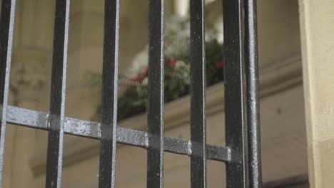 metal bars across church entrance with flower display