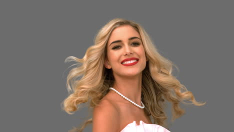 pretty woman tossing her hair on grey screen