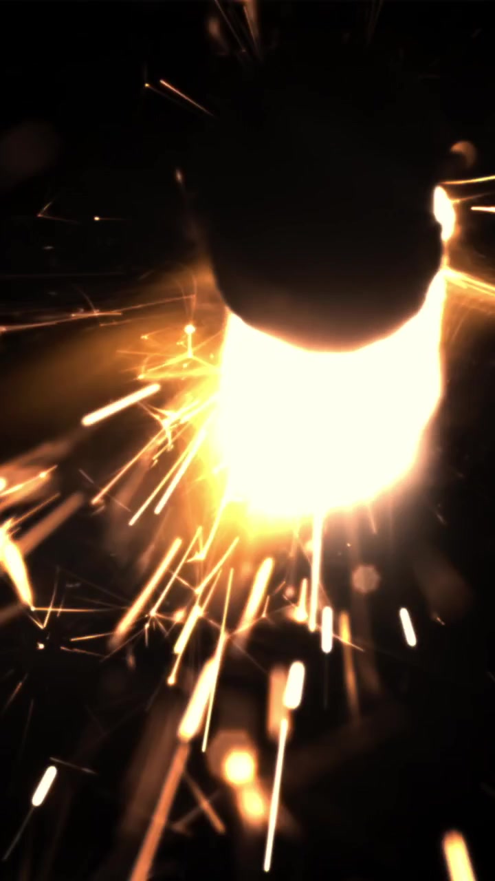 Bright Golden Sparks and Glowing Light on Dark Background