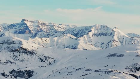 Silhouette-Einer-Schneebedeckten-Bergkette-Im-Morgengrauen-Von-Oben-Per-Drohne-Gesehen