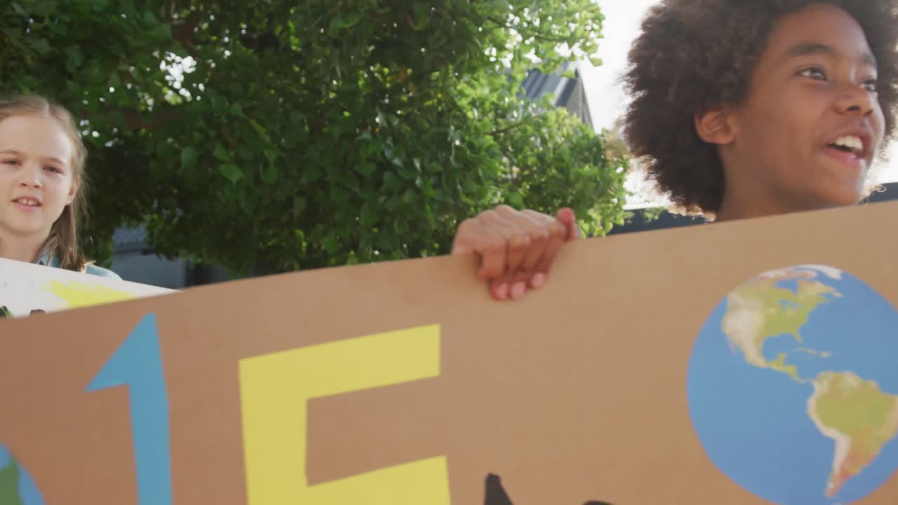 video de diversos escolares sosteniendo pancartas de protesta y cantando al aire libre, espacio de copia
