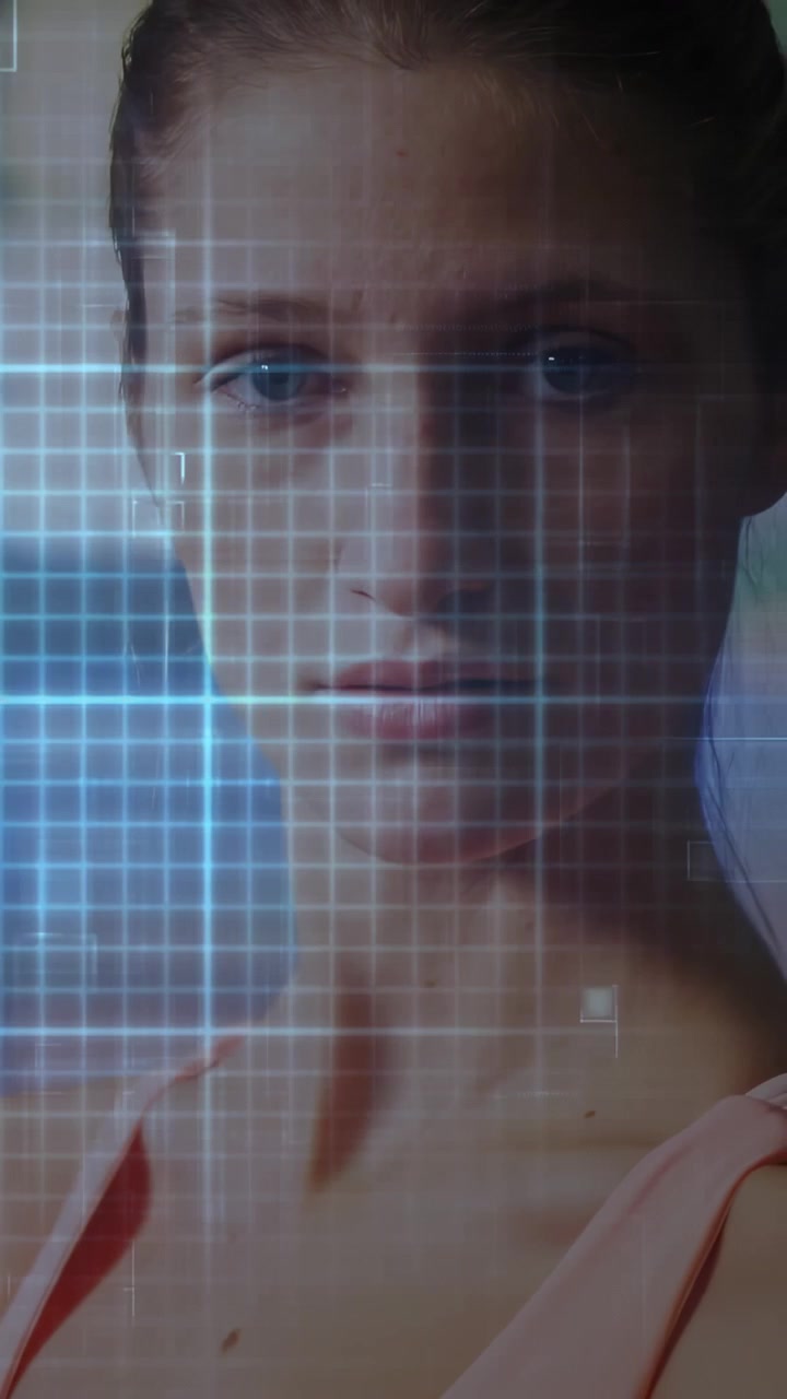 Vídeo vertical: Mulher virando-se para a câmera após movimento panorâmico, grade tecnológica, varredura HUD revelando o rosto para um retrato