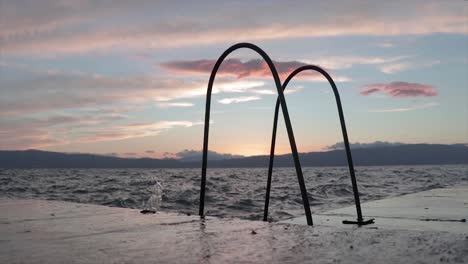 Waves-splashing-on-the-pier-of-a-natural-lake-at-sunset-with-a-beautiful-golden-hour