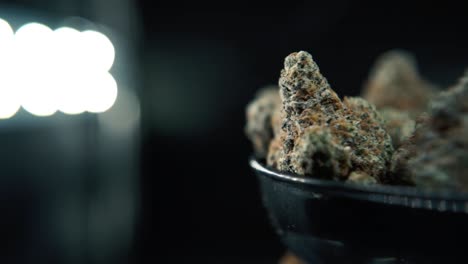 A-macro-follow-pan-right-shot-of-a-cannabis-plant,-hybrid-orange-strains,-sativa-,marijuana-flower,-on-a-rotating-stand,-Full-HD,-super-slow-motion,-120-fps,-studio-lighting