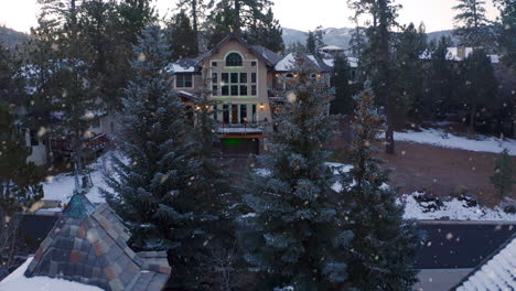 luxurious mansion between christmas pine trees, big bear lake town, california, morning winter snowfall