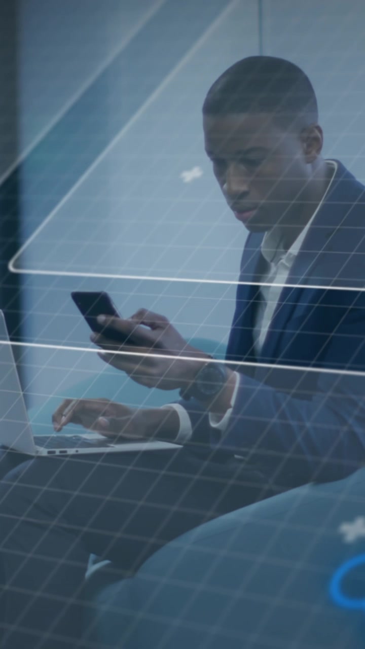 Young Black Man Working on Laptop and Phone with Digital Overlay