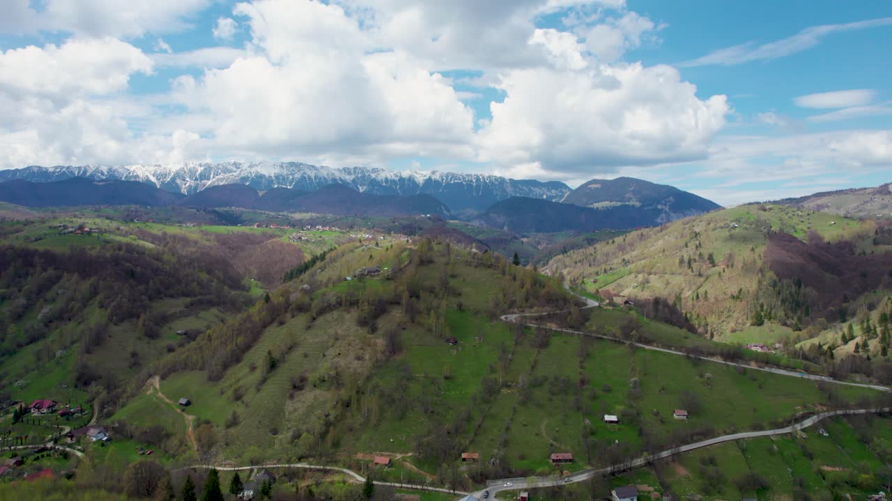 Unveiling the Breathtaking Beauty of Piatra Craiului Mountain Range- A Stunning Aerial View of Snowy Peaks, a Picturesque Village, and Verdant Landscapes in Romania, Transilvania, Moieciu, Rucar, Bran
