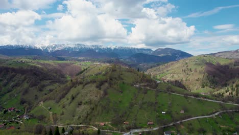 unveiling the breathtaking beauty of piatra craiului mountain range- a stunning aerial view of snowy peaks, a picturesque village, and verdant landscapes in romania, transilvania, moieciu, rucar, bran