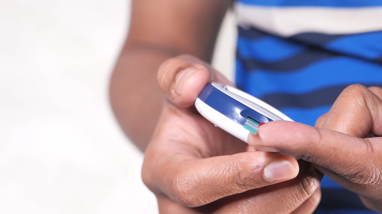 Child Using a Blood Glucose Meter to Test Blood Sugar