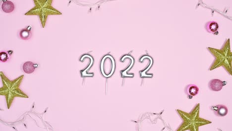 luces parpadeantes y adornos de navidad con 2022 en tema rosa pastel. stop motion