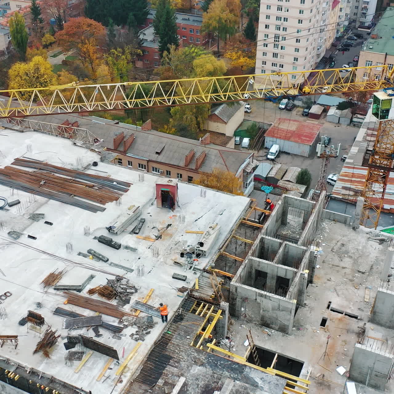 Aerial view of a new construction site. Top view on a roof of high-rise building in autumn on the city background.