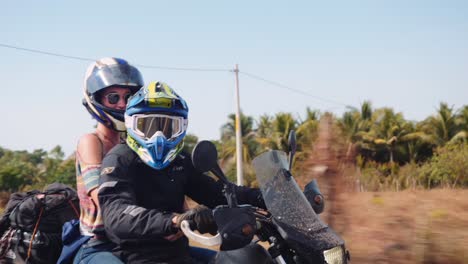 guy and girl riding together on dirt bike past guatemala jungle closeup at speed