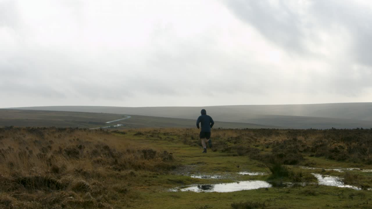 시골 배경과 건강한 라이프스타일 영국 4k를 유지하는 큰 웅덩이가 있는 시골길을 향해 달리는 남성 운동선수