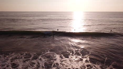 Luz-Solar-Brillante-Cayendo-Sobre-La-Superficie-Del-Mar-Con-Surfistas-Turísticos-En-La-Playa-De-Olon,-Ecuador