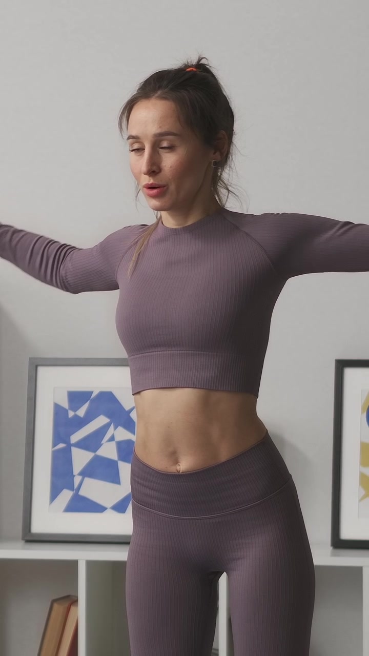 Donna in forma che esegue alzate laterali con manubri al chiuso