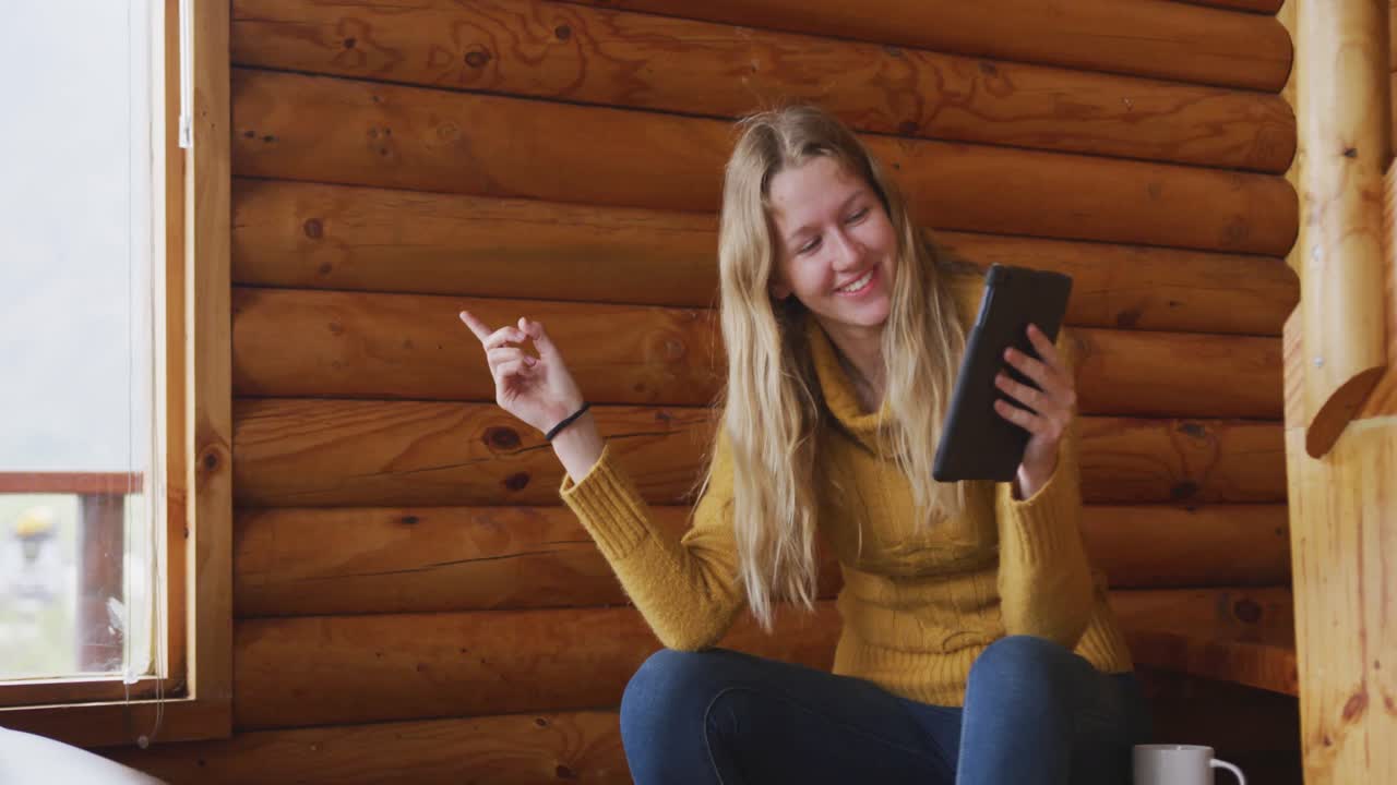 Caucasian woman spending time at home, using a tablet and smiling