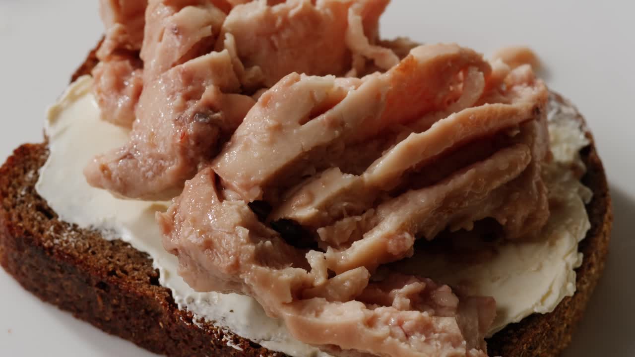 Smoked cod liver in oil in open tin can with fresh greens on wooden table. Seafoods delicacy. High quality 4k footage