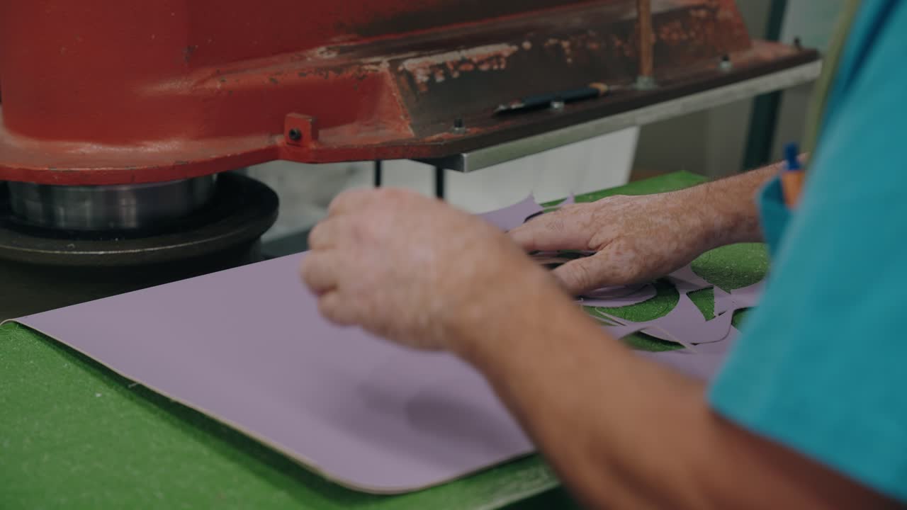 Close de prensa industrial cortando folha de material em formatos em processo de fábrica
