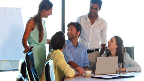 Businesspeople-having-a-discussion-while-using-laptop