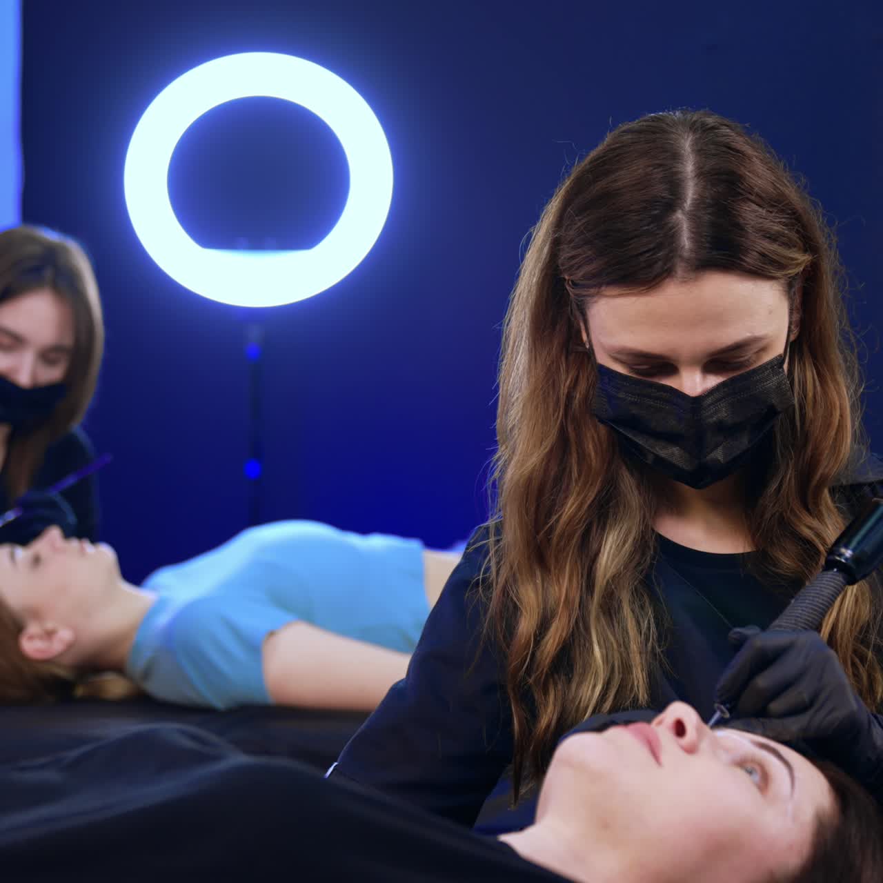 Masters of brow make up working in the salon. Beauty specialists use tools to perform procedure