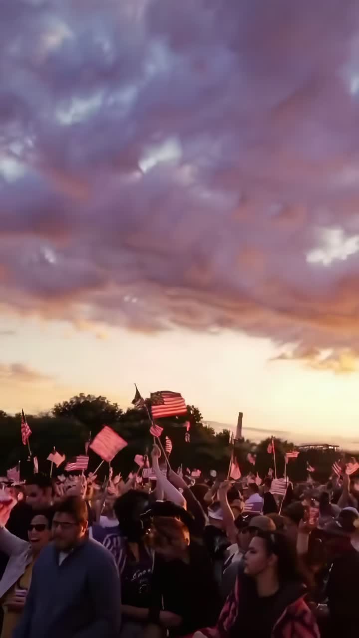 Lavvinkelvideo af folk, der vifter med flag ved solnedgang, der fanger en patriotisk og håbefuld stemning.