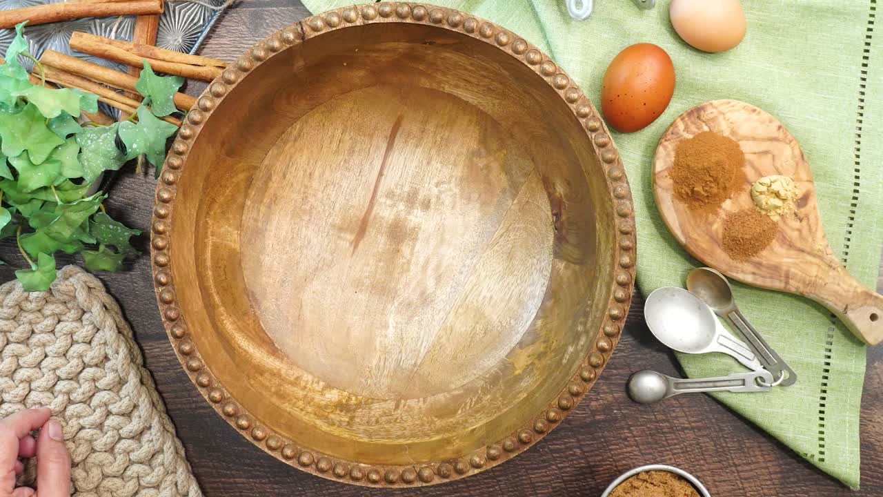 Baking a carrot cake loaf with cream cheese icing and topped with roasted salted pecans. Making a Autumn dessert with carrots, flour, sugar, nuts and frosting. Adding the brown sugar to the batter.