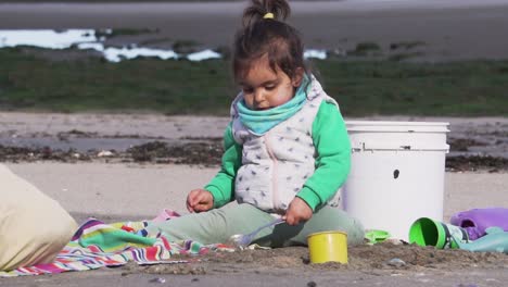 Una-Linda-Chica-Juega-Con-Sus-Juguetes-En-La-Playa,-A-Cámara-Lenta