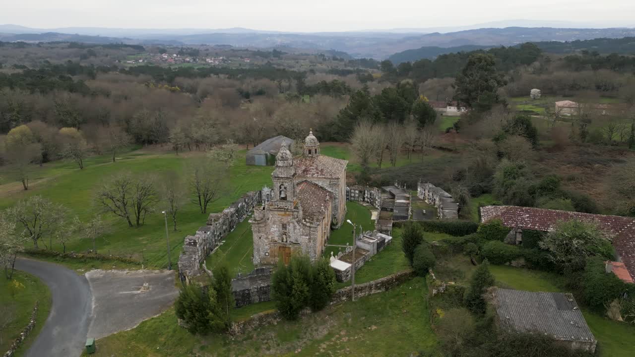 órbita aérea alrededor de los viejos terrenos cubiertos de hierba de la iglesia de santa maría de salamonde en san amaro, españa