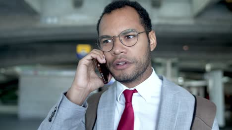 Businessman-talking-by-smartphone-in-airport