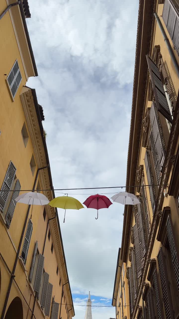 paraguas coloridos colgando en un callejón italiano