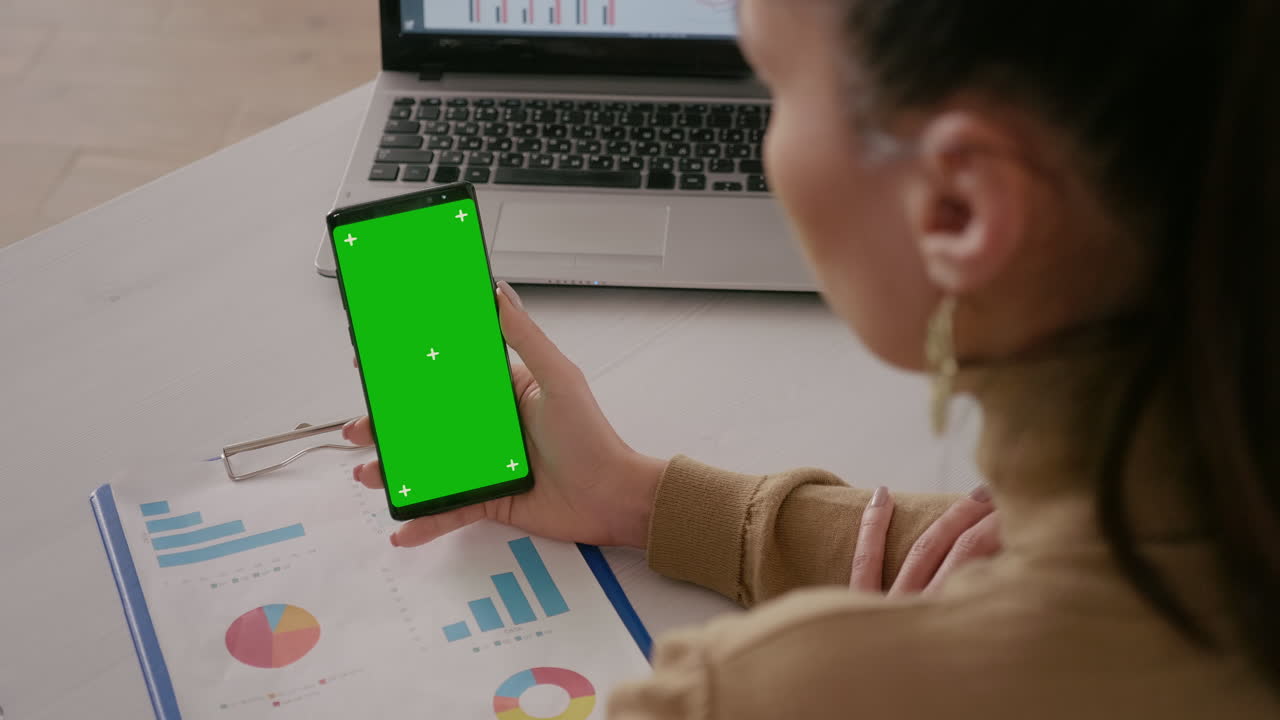 Close up of woman looking at telephone with green screen