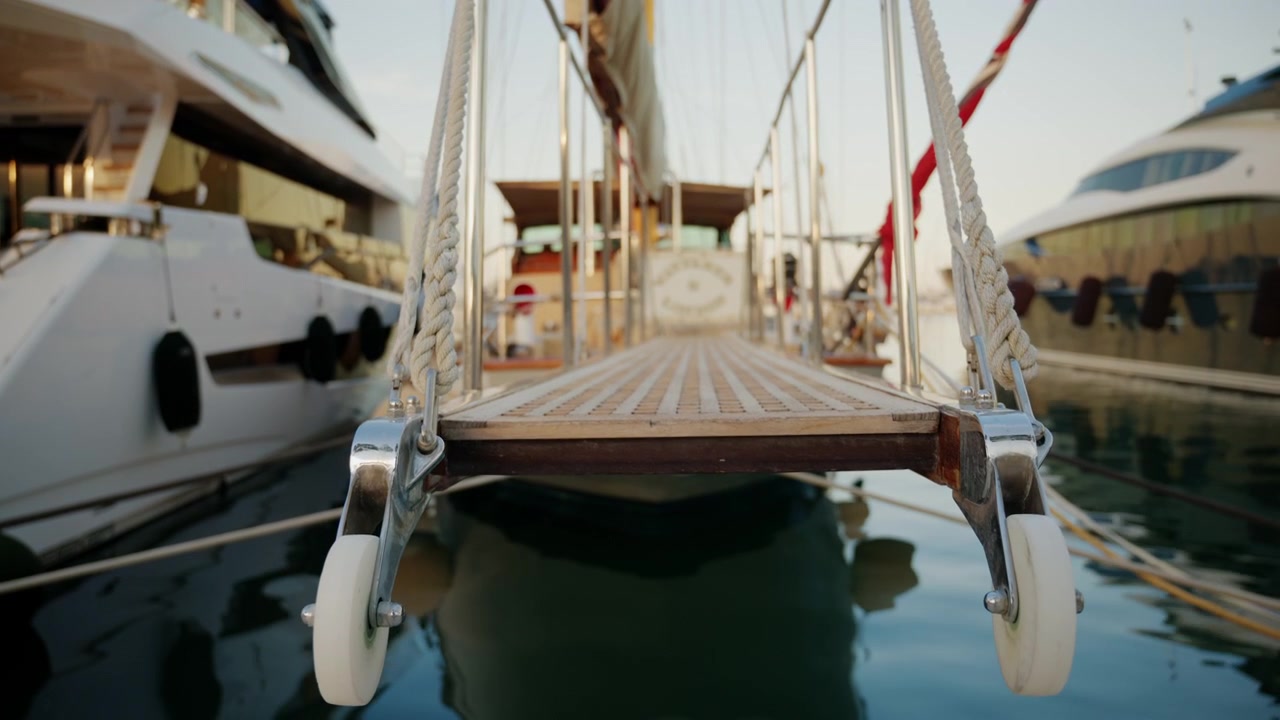 Kinoreife Nahaufnahme einer Yacht-Gangway zwischen Luxusbooten in einem Yachthafen.