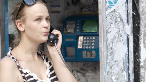 Attractive-woman-using-a-public-telephone