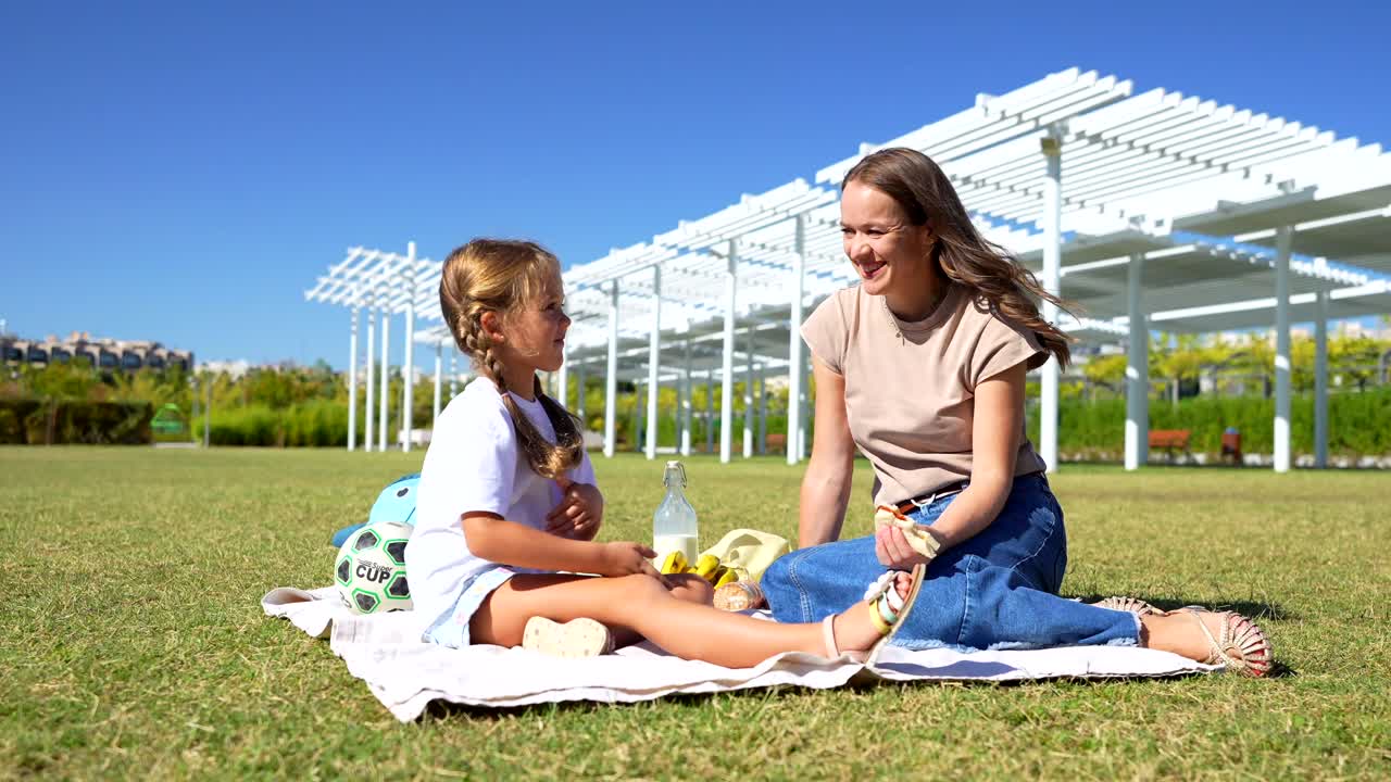 Mother and Daughter Enjoying a Picnic in the Park