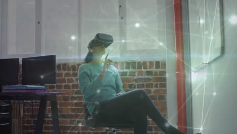 Animation-of-network-of-connections-over-businesswoman-using-vr-headset-in-office