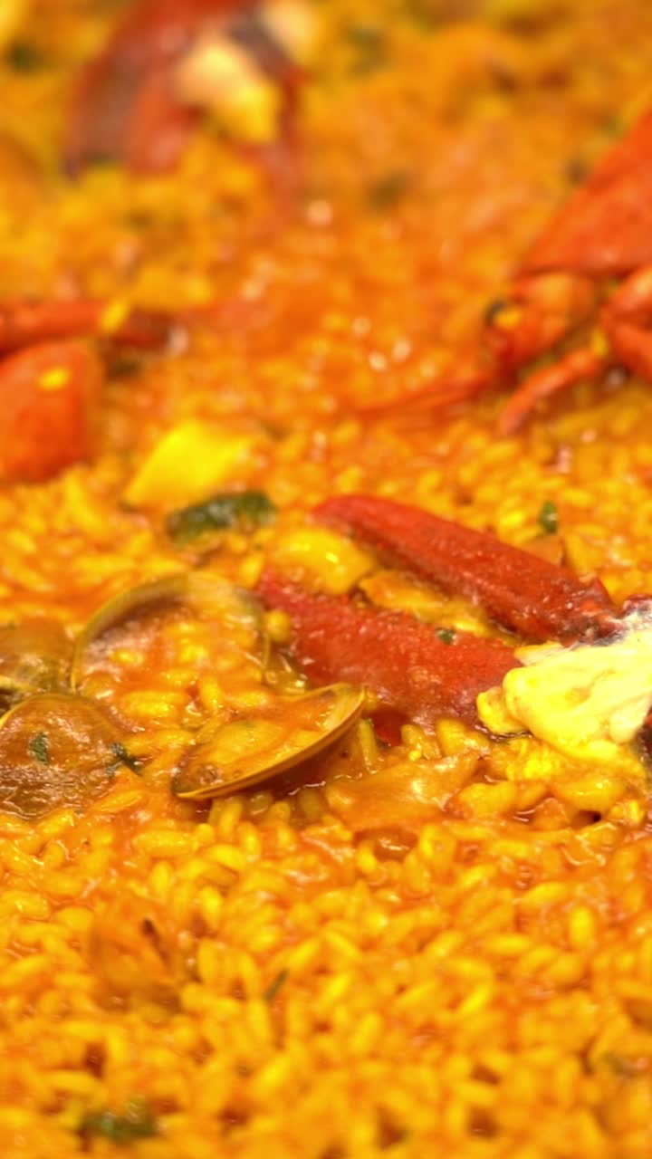 A plate of food with a yellow sauce and a lot of red shrimp