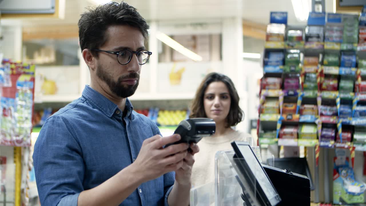 hombre pagando con tarjeta de crédito en el supermercado