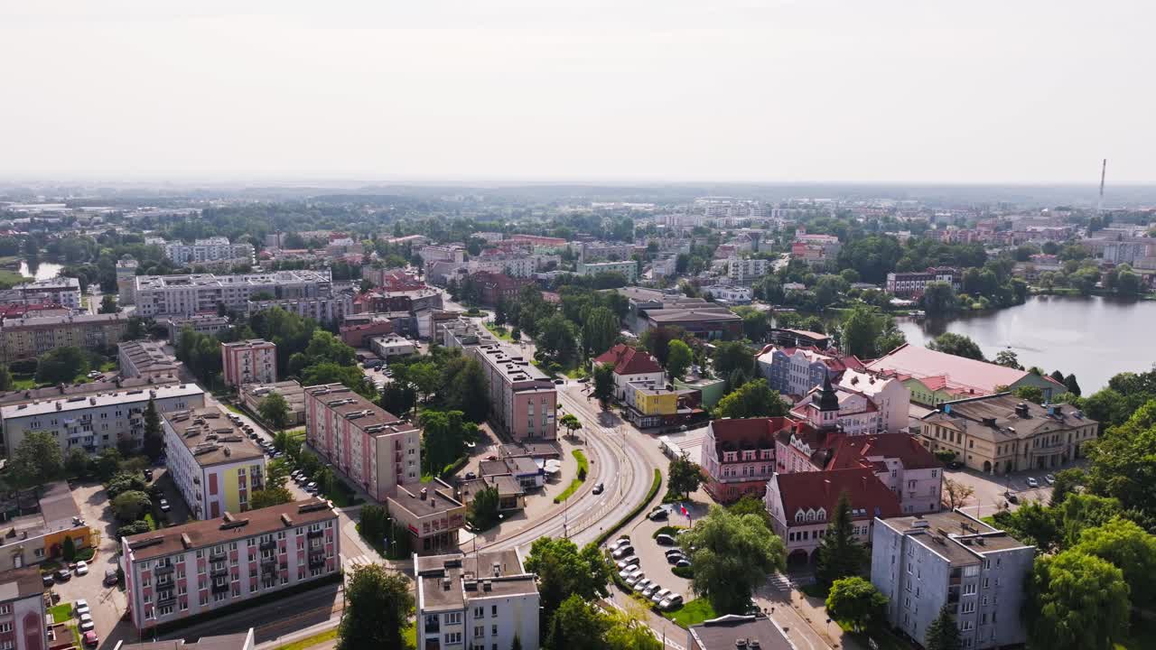 Cinematic aerial flying forward above Ilawa Poland city, rooftops and water