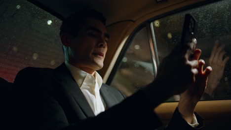 rich director videocalling smartphone in business car closeup. man making call