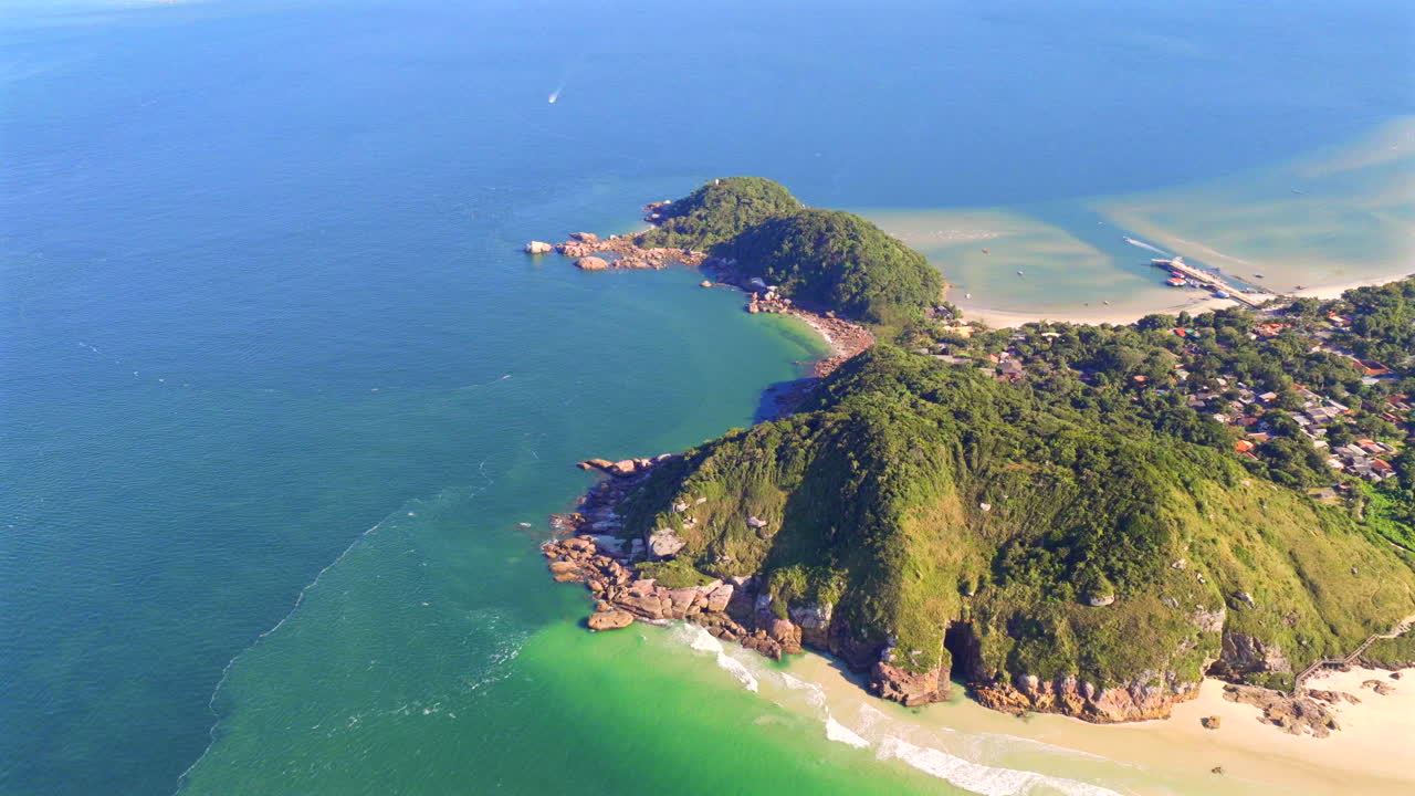 Aerial view of pristine coastline of Ilha do Mel, Paraná, Brazil, lush green cliffs meet crystal-clear turquoise waters