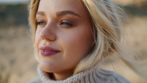 blonde woman smiling camera at autumn valley portrait. windy hair lady relaxing