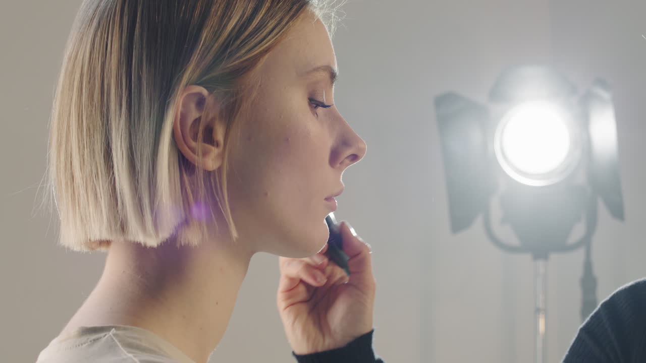 primer plano de mua poniendo maquillaje a una modelo femenina