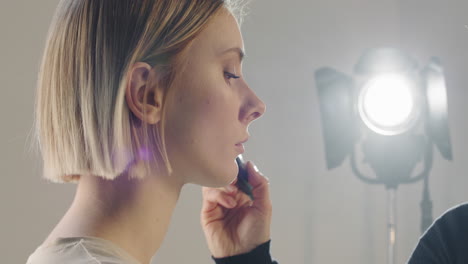 close up of mua putting make-up on female model