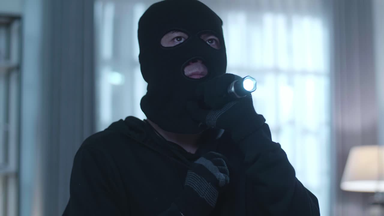 cerca de un ladrón hombre con una linterna caminando en la casa de alguien