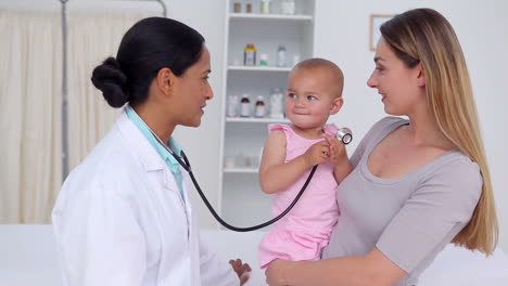 una mujer con su bebé hablando con un médico.