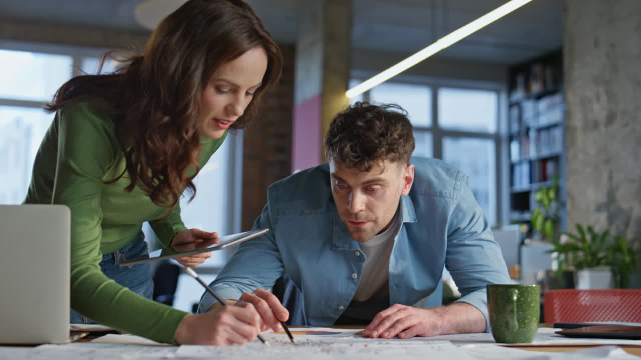Brainstorming couple looking documents office closeup. Colleagues drawing papers