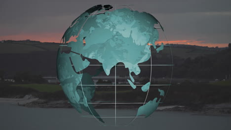 Rotating globe animation over coastal landscape during sunset