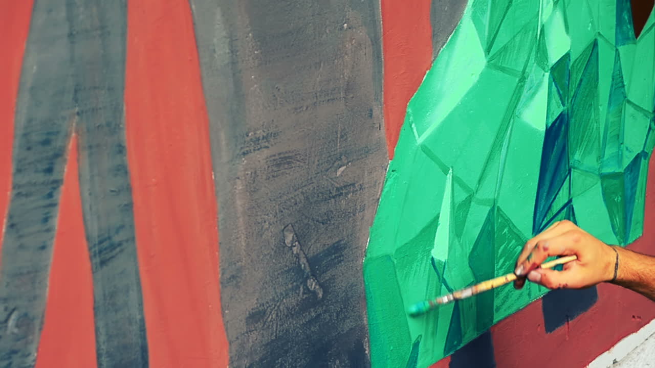 L'artista realizza graffiti su una recinzione. Disegno astratto